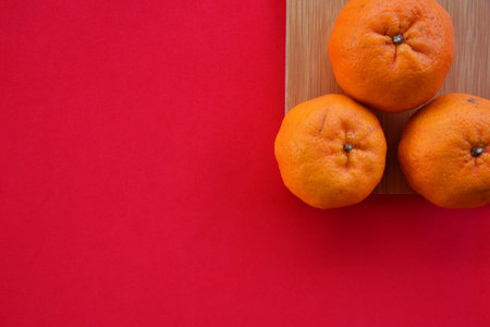 Orange on wood plate with red background top view concept. Selective focus image.