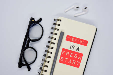 'Everyday is a fresh start' quote on the notebook with pen and spectacles white background concept.の写真素材
