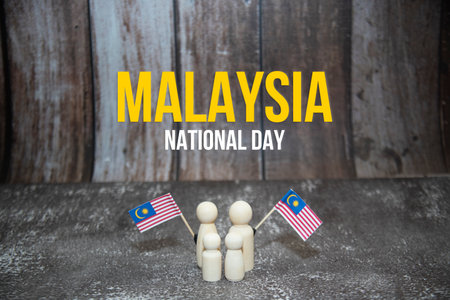 'Malaysia National Day' word with wooden dolls holding Malaysia mini flag.の写真素材