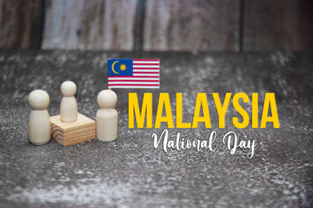 'Malaysia National Day' word with wooden dolls and Malaysia mini flag.の写真素材