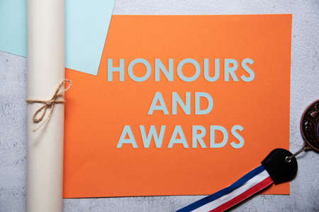 Honours and awards text on orange and baby blue background flat lay concept. Suitable to used as title cover each subtopic on resume or curriculum vitae.の写真素材
