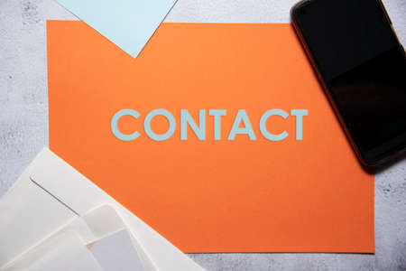 Contact text on orange and baby blue background flat lay concept. Suitable to used as title cover each subtopic on resume or curriculum vitae.の写真素材