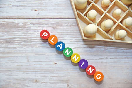 A group of wooden dolls with PLANNING text on colorful wooden blocks. Business concept.
