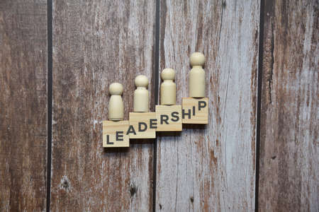 LEADERSHIP text on the wooden blocks under wooden dolls. Business concept.の写真素材