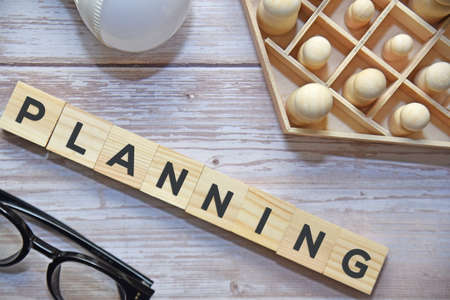 A group of wooden dolls with PLANNING text on wooden blocks. Business concept.