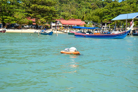 Langkawi Island, Kedah, Malaysia : 28th December 2020 - Landscape view of passengers boat and fishing boat at the beach.のeditorial素材