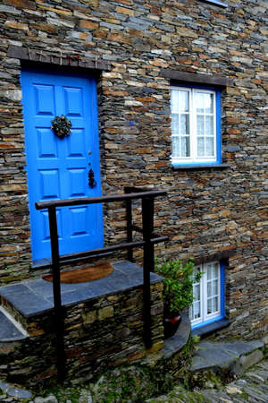 Rustic hand-hewn wood door set into a stone wall built from schist in Piodão, made of shale rocks stack, one of Portugal's schist villages in the Aldeias do Xisto.の写真素材