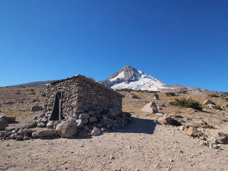 The Cooper Spur shelter on the Timberline Trail with Mount Hood and the Eliot Glacier in the background.の写真素材