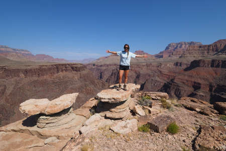 Young female backpacker enjoying a sweeping view of the canyon from the Tonto Trail in Grand Canyon...