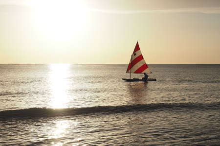 Captiva Island, Florida 08-05-2015 Active senior sails a Sunfish in late afternoon light off the beach in Captiva on Floridas Gulf Coast.のeditorial素材