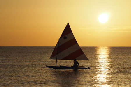 Captiva Island, Florida 08-05-2015 Active senior sails a Sunfish in late afternoon light off the beach in Captiva on Floridas Gulf Coast.のeditorial素材