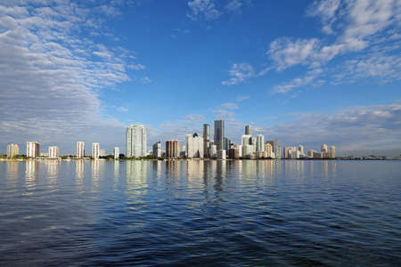Miami, Florida 11-24-2018 The skyline of the City of Miami, Florida, reflected in the calm water of Biscayne Bay in early morning light.の写真素材