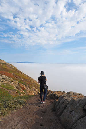 Point Reyes National Seashore, California 10-14-2015 Woman hikes and photographs the rugged landscape of Point Reyes in Northern California.のeditorial素材