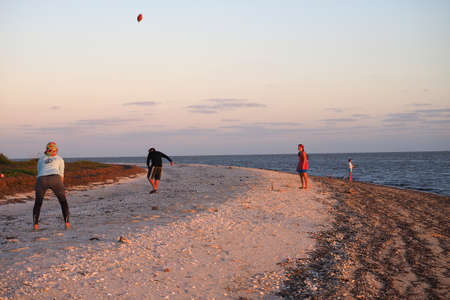 Everglades National Park, Florida 02-12-2017 Friends play football on the beach at East Cape Sable while backcountry camping.のeditorial素材