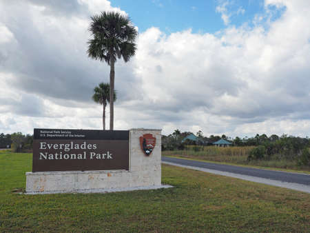 Everglades National Park, Florida - January 3, 2019: National Park Service sign at entrance to park with cloudscape in background.のeditorial素材