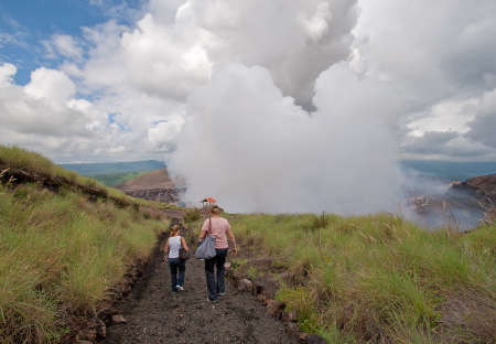 Masaya, Nicaragua - September 23, 2007: Two women view craters and gas emissions of Masaya Volcano from footpath near crater rim.のeditorial素材
