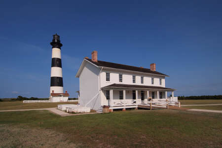 Nags Head, North Carolina - August 5, 2011 - Bodie Island Lighthouse and keepers house on cloudless summer afternoon with deep blue sky background.のeditorial素材