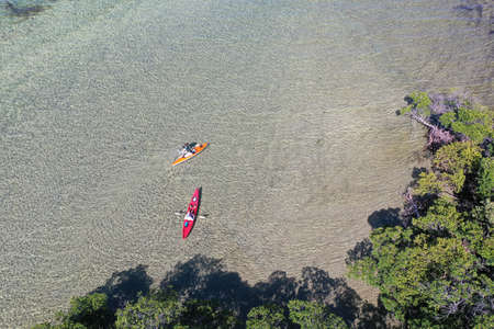 Key Biscayne, Florida - May 5, 2020 - Young couple enjoys afternoon of kayaking on calm, clear water of Bear Cut on sunny May afternoon.のeditorial素材