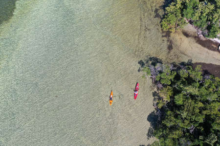 Key Biscayne, Florida - May 5, 2020 - Young couple enjoys afternoon of kayaking on calm, clear water of Bear Cut on sunny May afternoon.のeditorial素材