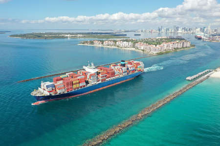 Miami Beach, Florida - May 23, 2020 - Aerial view of container ship in Government Cut leaving Port Miami on sunny calm summer morning.のeditorial素材