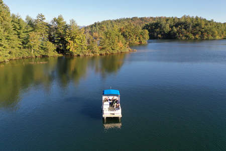 Aerial view of pontoon boat on Lake Santeetlah, North Carolina in autumn.