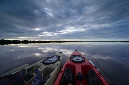 Everglades National Park, Florida - December 12, 2020 - Two kayaks at sunset on Coot Bay under dramatic winter cloudscape reflected in tranquil water.のeditorial素材
