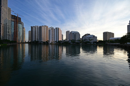City of Miami, Florida skyline reflected in still water of Biscayne Bay at sunrise.