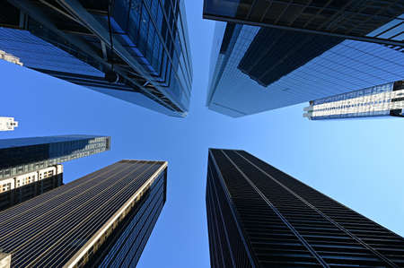 Upward view of skyscrapers in New York City, New York against clear blue sky.の写真素材