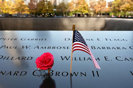 New York, New York - November 6, 2021 - Miniature American flags and flowers commemorate those lost on 911 at World Trade Center Memorial.のeditorial素材