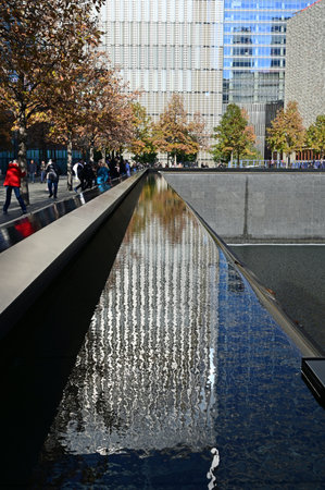 New York City, New York - November 6, 2021 - Reflecting pool and surrounding buildings at National September 11 Memorial on cloudless autumn afternoonのeditorial素材