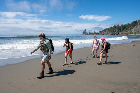Hikers on Shi Shi Beach Trail in Olympic National Park near Neah Bay, Washington on sunny summer afternoon with Point of Arches in background.の写真素材