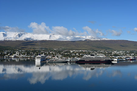 Akureyri, Iceland - September 9, 2023 - Akureyri and surrounding landscape reflected in perfectly calm water on clear tranquil sunny autumn morning.のeditorial素材