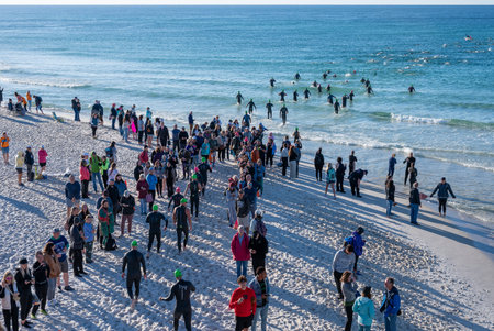 Panama City Beach, Florida - November 4, 2023 - Crowd of spectators and athletes on beach at start of 2023 Ironman competition.のeditorial素材