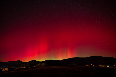 Red and green Aurora Borealis - Northern Lights - display over town of New Castle, Colorado of...
