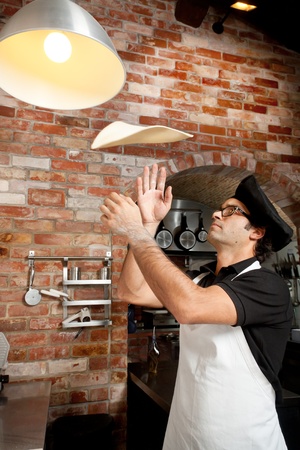 Pizza Chef makes the pizza dough spin in the air to make it thin and softの写真素材