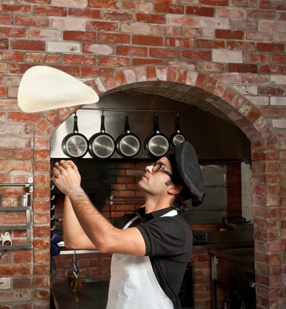 Pizza Chef makes the pizza dough spin in the air to make it thin and softの写真素材