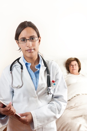 Doctor holding a cardboard with exams with a senior patient in the backgroundの写真素材
