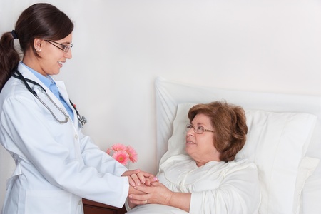 Standing Doctor, comforting recovering senior patientの写真素材
