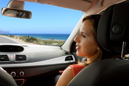 Couple enjoying their new car on a coastal roadの写真素材