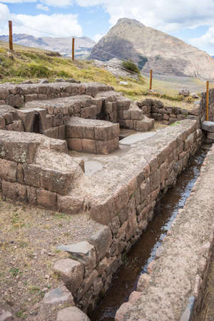 Stone walls, buildings, alley and canal in Pisac, Inca city of Sacred Valley, major travel destination in Cusco region, Peru.の写真素材
