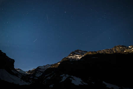 The starry sky on the Alps illuminated by moonlight. Expansive night landscape wide view.の写真素材