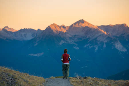 Backpacker walking on hiking trail in the mountain. Summer adventures summer vacation on the Alps. Wanderlust people traveling concept.の写真素材