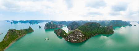 Aerial view of Ha Long Bay Cat Ba island, unique limestone rock islands and karst formation peaks in the sea, famous tourism destination in Vietnam. Scenic blue sky.の写真素材