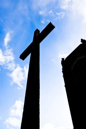 Silhouette of a back lit christian cross in the sky in front of the cathedralの写真素材