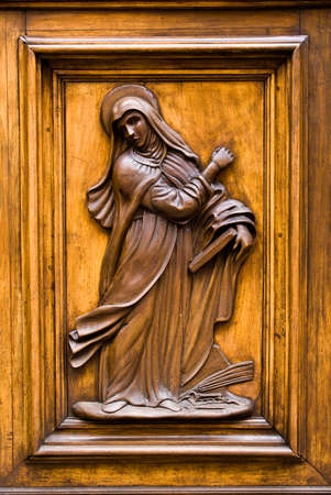 Virgin Mary carved in a wooden door in Florence, Italy.の写真素材