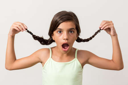 Girl suprised holding braidの写真素材