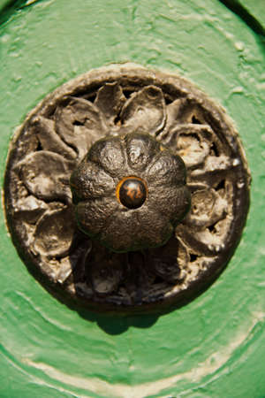 Iron door knob of a green wooden doorの写真素材