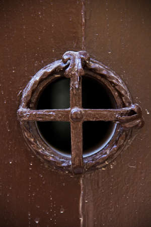 Little window with grid of an old wooden doorの写真素材