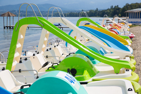 Colorful pedal boats aligned on a beach on Lake Geneva, Franceの写真素材