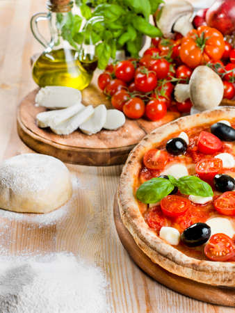 Italian pizza with tomato, mozzarella, basil and olivesの写真素材